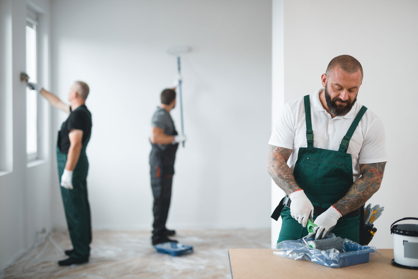 a person in overalls painting a room